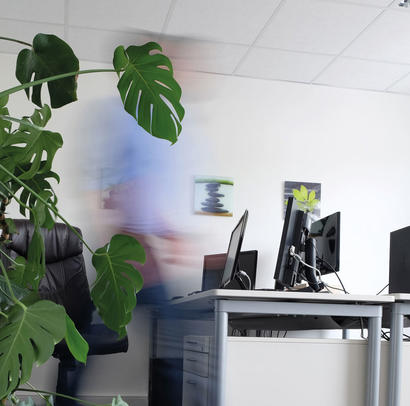 An employee on the move, leaving the workstation with screens.